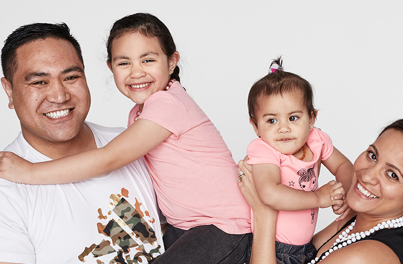 Family photo of Paisley with her sister and parents, smiling.