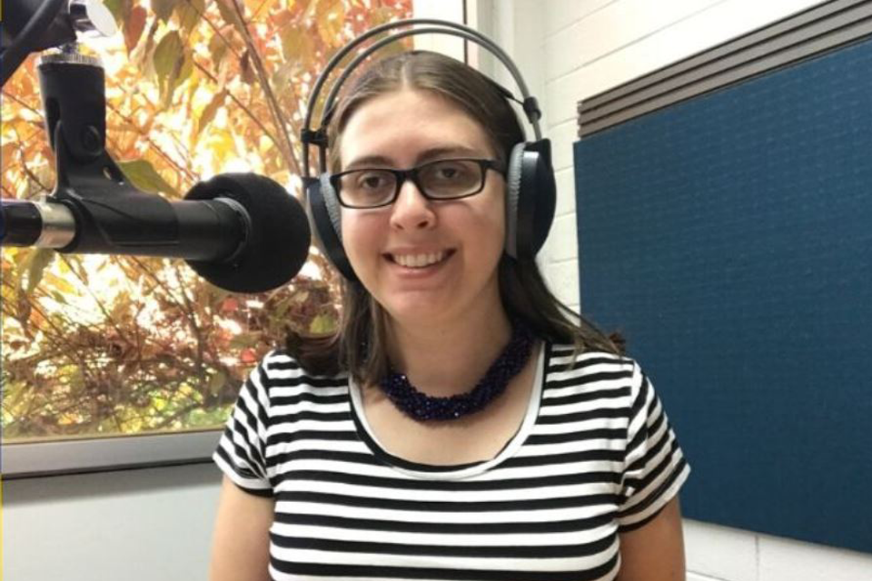 Presenter behind the microphone and wearing headphones