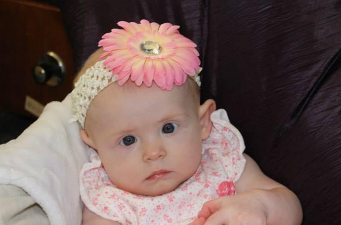 Amelia, aged 3 months, wearing a headband with a bright flower