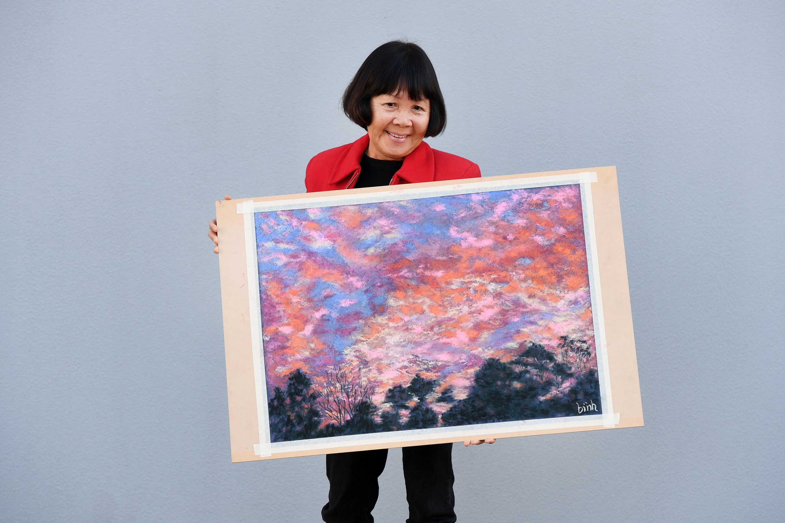 Binh holding her work that featured in the 2019 calendar