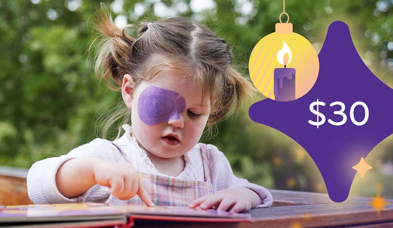 $30 Winter is pointing at page in a book and wearing a purple eye patch