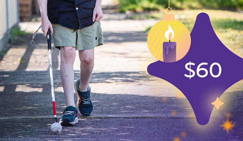 $60 a cropped scene where a child is using a white cane whilst walking along a footpath