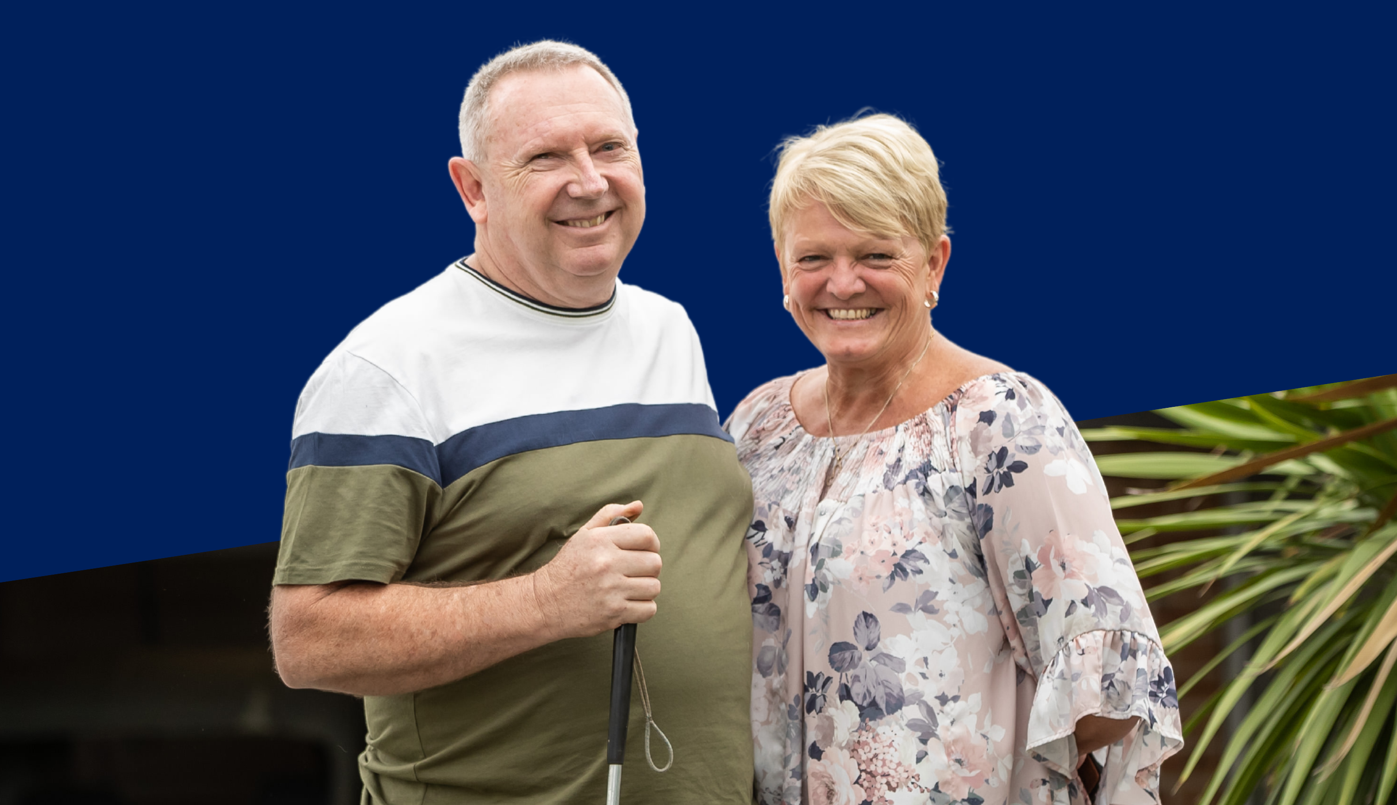 Man with cane standing with carer