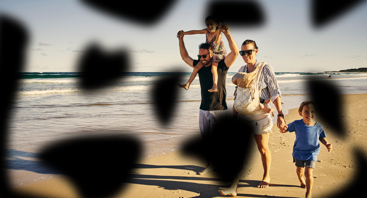 Diabetic retinopathy: Image of a happy family walking on the beach with dark blurred spots across various parts of the image.