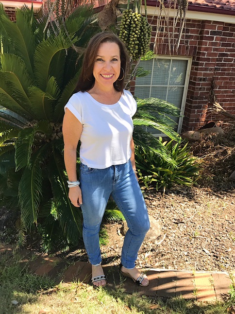 Image shows Marisa standing outside in a garden