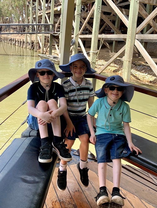 The three Bradley boys sit together in the bow of a boat