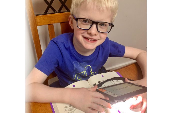Sam using a magnifier to read