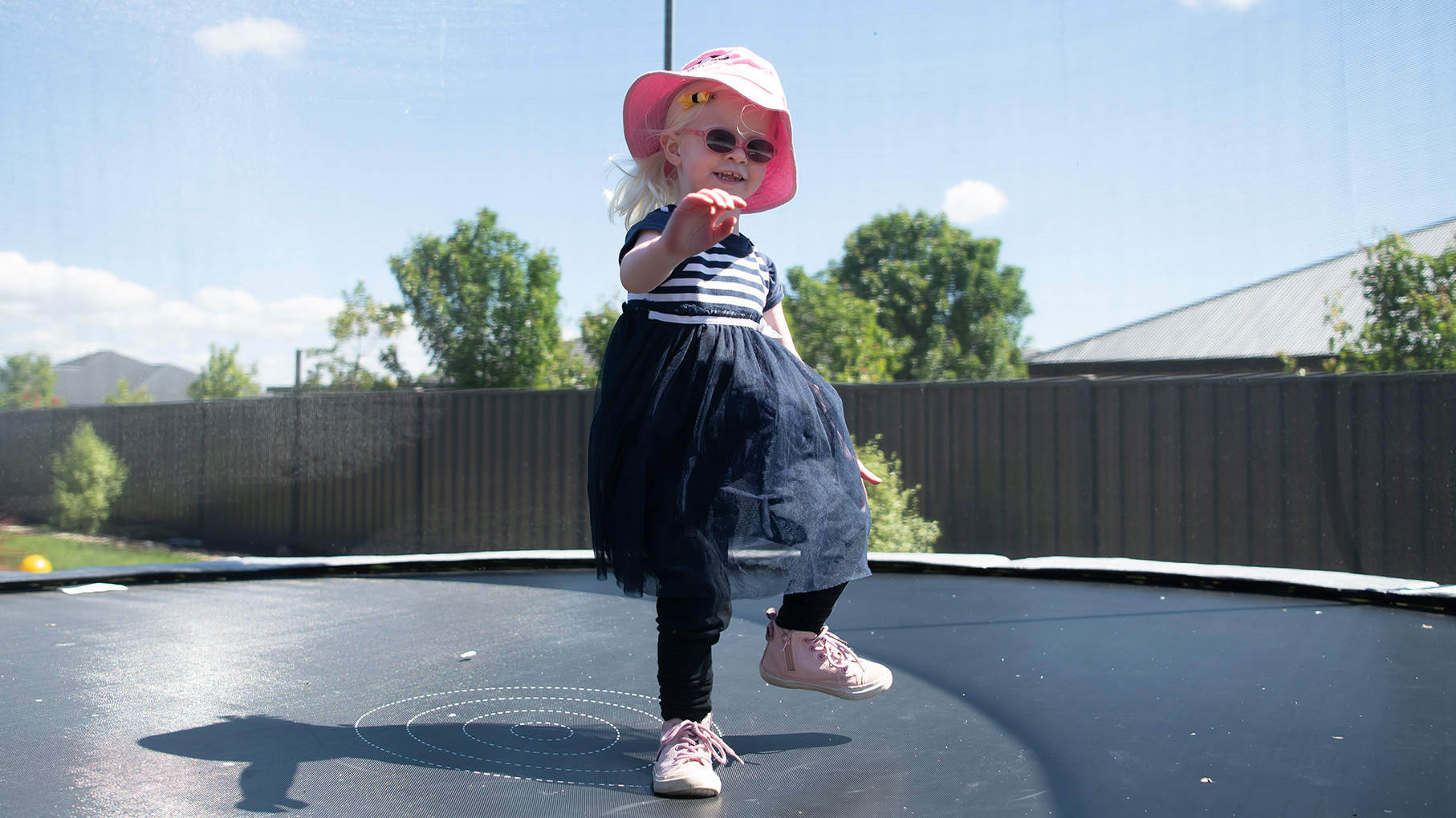 Hazel, aged 3, jumping happily on a trampoline