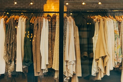 Image shows a rack of women's clothes in a shop window