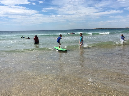 Image shows a young VA client surfing at the 2017 surf day