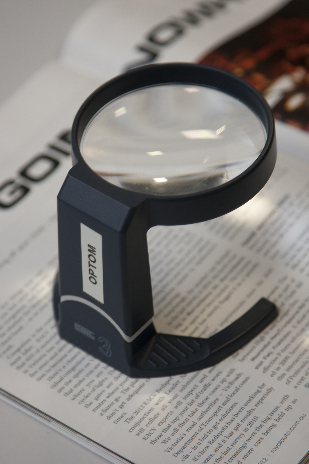 Non illuminated stand magnifier on a magazine
