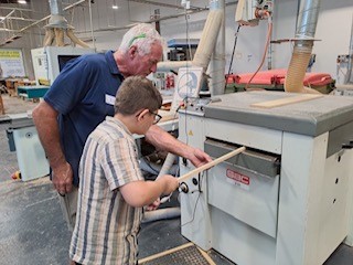 Workshop participant uses woodworking equipment