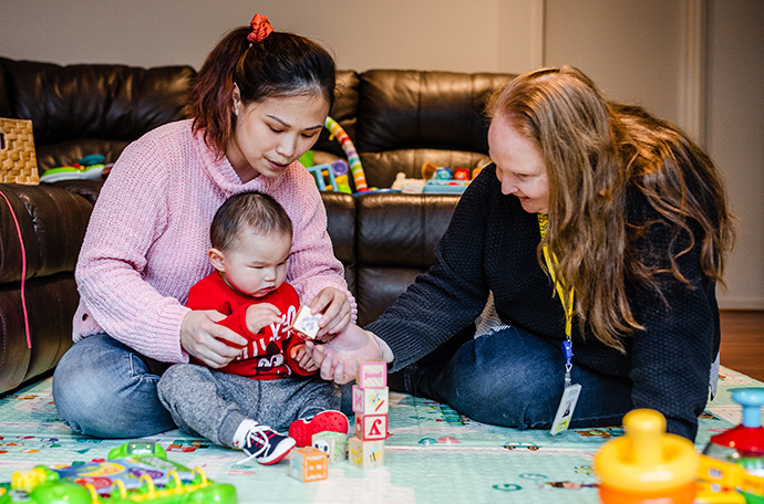 Nicholas is playing with block, with his mum and Vision Australia's early childhood specialist teacher 
