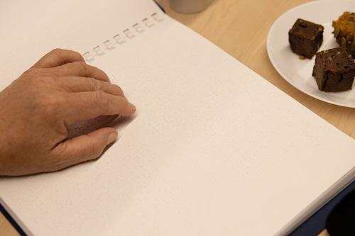 A hand on a page of braille