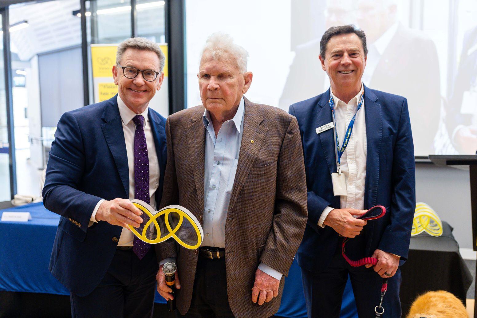 David Blythe holds his award and takes a photo with David Williamson and Mark Grey